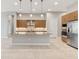 A modern island kitchen featuring granite countertops, wooden cabinets, and stainless steel appliances at 8936 Artisan Way, Sarasota, FL 34240