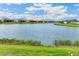 A serene lake view shows the waterfront and surrounding properties on a bright, sunny day at 8936 Artisan Way, Sarasota, FL 34240