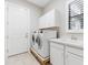 Laundry room featuring modern washer and dryer, cabinetry, and a sink with granite countertops at 8936 Artisan Way, Sarasota, FL 34240