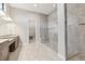 Bright bathroom featuring double vanity, walk-in shower with glass enclosure, and walk-in closet at 8936 Artisan Way, Sarasota, FL 34240