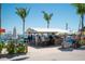 Vibrant outdoor bar area with patrons enjoying drinks, featuring palm trees and a casual, beachside vibe at 901 Gulf S Dr # 14, Bradenton Beach, FL 34217