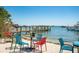 Outdoor dining area with colorful chairs, tables, and a pier in the background at 901 Gulf S Dr # 14, Bradenton Beach, FL 34217