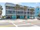 Charming three-story building with screened balconies, lush palm trees, and convenient covered parking at 901 Gulf S Dr # 14, Bradenton Beach, FL 34217
