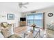Bright living room featuring a ceiling fan, comfortable seating, and sliding doors that offer beautiful water views at 901 Gulf S Dr # 14, Bradenton Beach, FL 34217