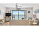 Relaxing living room with comfortable seating and expansive sliding doors showcasing stunning views of the water at 901 Gulf S Dr # 14, Bradenton Beach, FL 34217