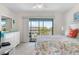 Bright main bedroom with a balcony overlooking palm trees and the community pool at 901 Gulf S Dr # 14, Bradenton Beach, FL 34217