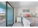 Bright main bedroom with a balcony overlooking palm trees and the community pool at 901 Gulf S Dr # 14, Bradenton Beach, FL 34217