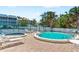 Beautiful outdoor community pool and spa area surrounded by palm trees and tennis courts at 901 Gulf S Dr # 14, Bradenton Beach, FL 34217