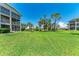 Expansive grassy backyard view with mature trees between buildings at 9620 Club South Cir # 5208, Sarasota, FL 34238