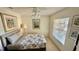 Cozy bedroom features a ceiling fan, neutral tones, and a large window for natural light at 4812 Sand Trap E Cir, Bradenton, FL 34203
