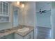 Bathroom featuring vanity with granite countertop, cabinet, and a view into an adjacent bedroom at 104 1St Ave, Venice, FL 34285