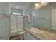 Bathroom features a walk-in shower, granite countertops, and ample lighting at 104 1St Ave, Venice, FL 34285