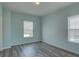 Sunlit bedroom with modern flooring, fresh paint, and window overlooking neighborhood at 104 1St Ave, Venice, FL 34285