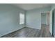Bedroom with light blue paint, wood grain floors, a bright window, and access to the rest of the house at 104 1St Ave, Venice, FL 34285