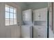 Laundry room with stackable washer and dryer, utility sink, white cabinets, and wood grain floors at 104 1St Ave, Venice, FL 34285