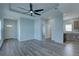 Open floor plan with recessed lighting, tray ceiling with fan, wood grain floors, and light blue paint at 104 1St Ave, Venice, FL 34285
