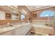 Luxurious bathroom with double vanity, framed mirrors, a soaking tub, and decorative tile accents at 1085 Mallard Marsh Dr, Osprey, FL 34229