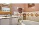 Elegant bathroom featuring a long vanity with marble countertop and built-in tub with tile surround at 1085 Mallard Marsh Dr, Osprey, FL 34229