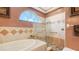 Well-designed bathroom with a soaking tub, a glass shower with stone floor, and tiled walls at 1085 Mallard Marsh Dr, Osprey, FL 34229