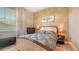 Inviting bedroom featuring a patterned bedspread, carpet flooring, and a window for natural light at 1085 Mallard Marsh Dr, Osprey, FL 34229