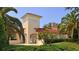 Community clubhouse with tropical landscaping, a clock tower, and a secure gated entry at 1085 Mallard Marsh Dr, Osprey, FL 34229