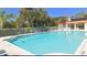 Large community pool surrounded by fence, chairs, cabana, and lush landscaping at 1085 Mallard Marsh Dr, Osprey, FL 34229