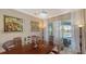 Dining room featuring a large wooden table, modern art, and view of the outdoor pool at 1085 Mallard Marsh Dr, Osprey, FL 34229