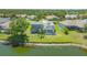 Back exterior view showcasing a spacious yard, screened-in lanai, and waterfront access at 1085 Mallard Marsh Dr, Osprey, FL 34229