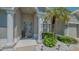 Inviting front entrance with pillars, a decorative door, and lush landscaping with palm tree at 1085 Mallard Marsh Dr, Osprey, FL 34229