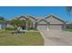 Charming single-story home with a well-manicured lawn, mature landscaping, and a three-car garage at 1085 Mallard Marsh Dr, Osprey, FL 34229
