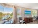 Living room with large window and lake view beyond adjacent to a dresser and piano at 1085 Mallard Marsh Dr, Osprey, FL 34229