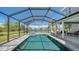 A stunning screened pool and spa overlooks a tranquil lake view, with outdoor seating on the patio at 1085 Mallard Marsh Dr, Osprey, FL 34229