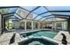 A backyard featuring a screened pool, spa, and patio, perfect for outdoor relaxation and entertainment at 1085 Mallard Marsh Dr, Osprey, FL 34229