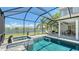 A screened pool and spa area with lush landscaping and lake views create a private oasis at 1085 Mallard Marsh Dr, Osprey, FL 34229