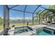 An inviting pool and spa area with a screened enclosure and lake views at 1085 Mallard Marsh Dr, Osprey, FL 34229