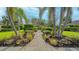 Inviting walkway lined with lush greenery and palm trees leading to the property at 1085 Mallard Marsh Dr, Osprey, FL 34229
