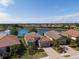 Aerial view of lovely homes showcasing tile roofs, paver driveways, and beautiful landscaping near a lake at 12740 Del Corso Loop, Lakewood Ranch, FL 34211
