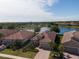Aerial view of beautiful homes featuring tile roofs, lush landscaping, and a serene lake at 12740 Del Corso Loop, Lakewood Ranch, FL 34211