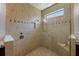 This bathroom shower features elegant tilework, a built-in shower seat, and a frosted window for natural light at 12740 Del Corso Loop, Lakewood Ranch, FL 34211