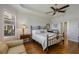 Bedroom showcases trey ceiling, plantation shutters, wood floors, and a decorative metal bedframe at 12740 Del Corso Loop, Lakewood Ranch, FL 34211