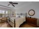 Bright bedroom featuring tray ceilings, a decorative metal bed frame, and scenic views through large windows at 12740 Del Corso Loop, Lakewood Ranch, FL 34211