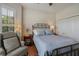 Comfortable bedroom features a decorative metal bed frame, wood floors, and a bright window view at 12740 Del Corso Loop, Lakewood Ranch, FL 34211