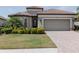 Inviting home exterior with a manicured lawn, beautiful landscaping, and a two-car garage at 12740 Del Corso Loop, Lakewood Ranch, FL 34211