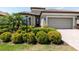 Charming home with a manicured front garden, lush bushes and a two car garage at 12740 Del Corso Loop, Lakewood Ranch, FL 34211
