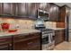 Modern kitchen featuring stainless steel appliances, granite countertops, and dark wood cabinetry at 12740 Del Corso Loop, Lakewood Ranch, FL 34211