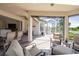 Spacious outdoor living area with seating, brick flooring, ceiling fan, and views of the pool and lake at 12740 Del Corso Loop, Lakewood Ranch, FL 34211