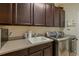The laundry room features stainless steel appliances, sink and plentiful dark cabinetry at 12740 Del Corso Loop, Lakewood Ranch, FL 34211