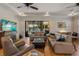 Elegant living room with neutral tones, tray ceiling, and beautiful view of the lake through sliding glass doors at 12740 Del Corso Loop, Lakewood Ranch, FL 34211