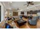 Open-concept living room with hardwood floors, ceiling fans, and a view into a spacious kitchen at 12740 Del Corso Loop, Lakewood Ranch, FL 34211