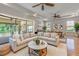 Bright living room boasts neutral tones, tray ceiling, ceiling fans, and an oversized sliding door to the lanai at 12740 Del Corso Loop, Lakewood Ranch, FL 34211